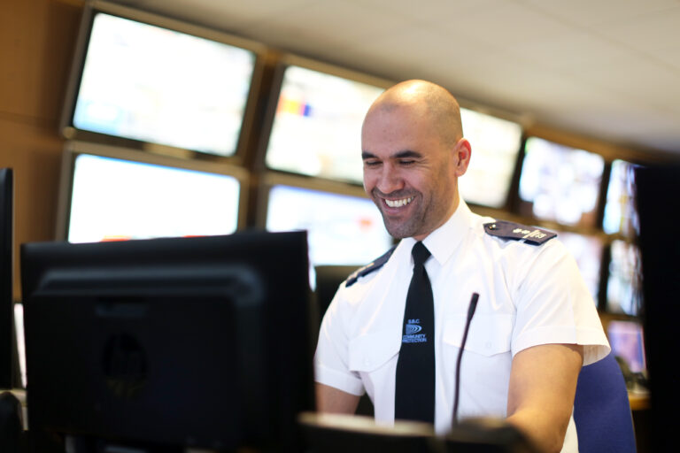 Security guard smiling at computer screen