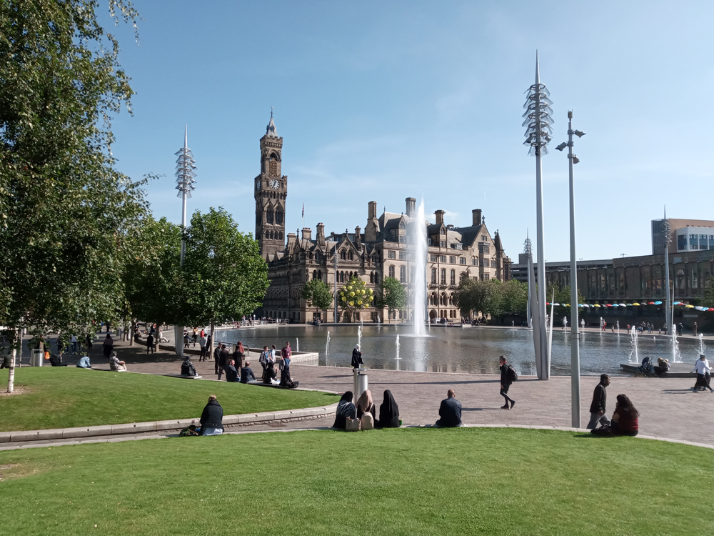 Large building in Bradford in the sun. Water fountain in front - Bradford council, occupational health consultants