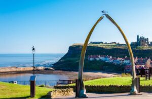 Whalebone arch in Whitby with sea and cliffs in background